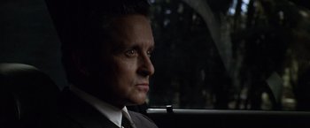 Movie still from “The Game” (1997), directed by David Fincher – A person wearing a suit in a car; Close Up shot, Over the shoulder angle