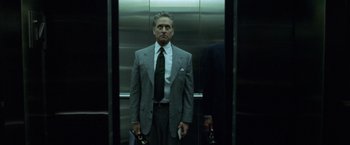 Movie still from “The Game” (1997), directed by David Fincher – A man in a suit and tie standing in an elevator; Medium shot, Low angle