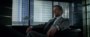 Movie still from “The Game” (1997), directed by David Fincher – A man in a suit and tie sitting in a chair; Medium shot, Low angle