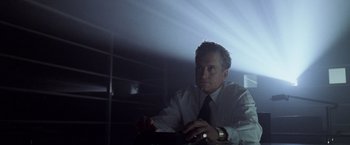 Movie still from “The Game” (1997), directed by David Fincher – A man in a suit and tie looking at the camera; Medium shot, Low angle