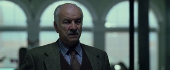 Movie still from “The Game” (1997), directed by David Fincher – An older man with a mustache wearing a suit; Close Up shot, Low angle