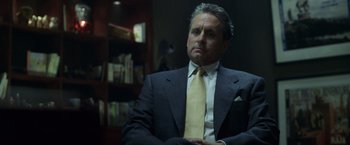 Movie still from “The Game” (1997), directed by David Fincher – A man in a suit and tie sitting in a room; Close Up shot, Over the shoulder angle