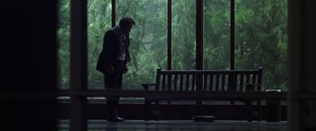 Movie still from “The Game” (1997), directed by David Fincher – A man standing in front of a window talking on a phone; Wide shot, Low angle