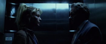 Movie still from “The Game” (1997), directed by David Fincher – A man and a woman facing each other in front of an elevator; Close Up shot, Overhead angle