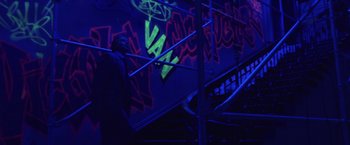 Movie still from “The Game” (1997), directed by David Fincher – A man standing on top of a set of stairs in the dark; Wide shot, Low angle