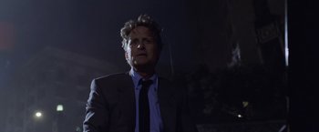 Movie still from “The Game” (1997), directed by David Fincher – A man in a suit and tie smoking a cigarette; Medium shot, Low angle