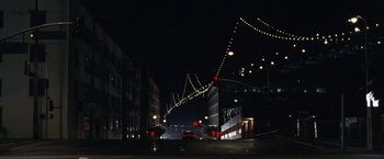 Movie still from “The Game” (1997), directed by David Fincher – A city street at night lit up by street lights; Extreme Wide shot, High angle