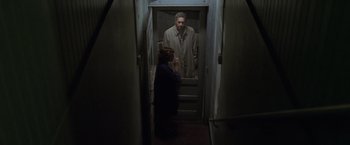 Movie still from “The Game” (1997), directed by David Fincher – A man and a woman are standing in a doorway; Wide shot, High angle