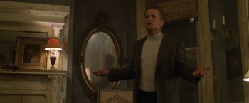Movie still from “The Game” (1997), directed by David Fincher – A man standing in front of a mirror in a room; Medium shot, Low angle