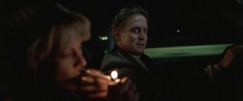 Movie still from “The Game” (1997), directed by David Fincher – A man sitting in the back of a car holding a lit cigarette; Close Up shot, Low angle