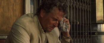 Movie still from “The Game” (1997), directed by David Fincher – A man holding a cell phone to his ear; Close Up shot, Low angle