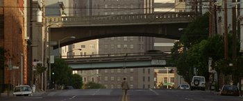 Movie still from “The Game” (1997), directed by David Fincher – A man standing in the middle of the road under an overpass; Extreme Wide shot, High angle