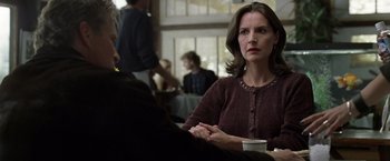 Movie still from “The Game” (1997), directed by David Fincher – A woman sitting at a table with a cup of coffee; Close Up shot, Over the shoulder angle