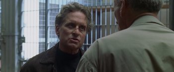 Movie still from “The Game” (1997), directed by David Fincher – A man in a black shirt is talking to another man in a brown jacket; Close Up shot, Over the shoulder angle