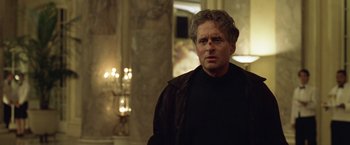 Movie still from “The Game” (1997), directed by David Fincher – A man in a black shirt and a brown jacket; Close Up shot, Over the shoulder angle