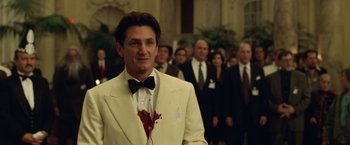 Movie still from “The Game” (1997), directed by David Fincher – A man in a white suit with blood on his chest; Medium shot, Over the shoulder angle