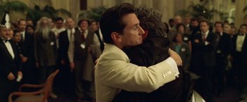 Movie still from “The Game” (1997), directed by David Fincher – Two men hugging each other in a crowd of onlookers; Close Up shot, Over the shoulder angle