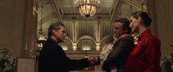 Movie still from “The Game” (1997), directed by David Fincher – Two men shaking hands in a large room; Medium shot, Low angle