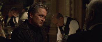 Movie still from “The Game” (1997), directed by David Fincher – A man sitting at a table with a glass of wine; Close Up shot, Over the shoulder angle