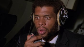 Movie still from “Airplane!” (1980), directed by David Zucker – A person wearing a suit and tie; Close Up shot, Low angle