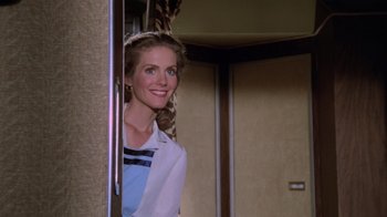 Movie still from “Airplane!” (1980), directed by David Zucker – A woman standing in a doorway smiling for the camera; Medium shot, Over the shoulder angle
