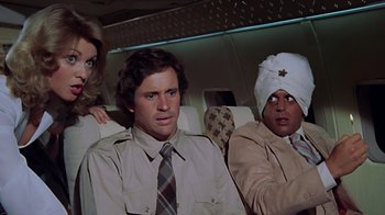 Movie still from “Airplane!” (1980), directed by David Zucker – A group of people sitting on top of an airplane; Medium shot, Over the shoulder angle