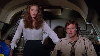 Movie still from “Airplane!” (1980), directed by David Zucker – A man and a woman standing next to each other; Medium shot, High angle