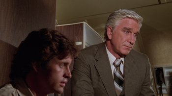 Movie still from “Airplane!” (1980), directed by David Zucker – A man and a boy in a suit and tie; Close Up shot, Low angle