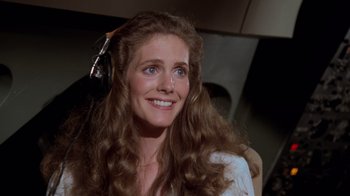 Movie still from “Airplane!” (1980), directed by David Zucker – A beautiful woman with long brown hair wearing a white shirt; Close Up shot, High angle