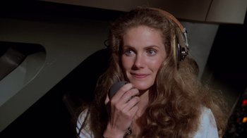 Movie still from “Airplane!” (1980), directed by David Zucker – A woman wearing headphones and holding a cell phone; Close Up shot, High angle
