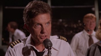 Movie still from “Airplane!” (1980), directed by David Zucker – A person with a microphone; Close Up shot, Low angle
