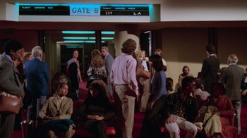 Movie still from “Airplane!” (1980), directed by David Zucker – A group of people standing in front of an airport gate; Wide shot, High angle
