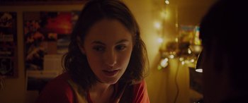 Movie still from “Alex Strangelove” (2018), directed by Craig Johnson – A woman is looking at the camera with a smile; Close Up shot, Over the shoulder angle