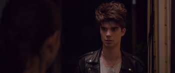 Movie still from “Alex Strangelove” (2018), directed by Craig Johnson – A young man with brown hair wearing a leather jacket; Close Up shot, Over the shoulder angle