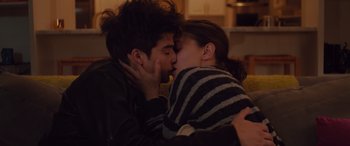 Movie still from “Alex Strangelove” (2018), directed by Craig Johnson – A man and a woman kissing each other in a living room; Close Up shot, Overhead angle