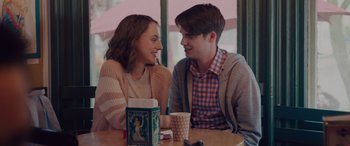 Movie still from “Alex Strangelove” (2018), directed by Craig Johnson – A man and a woman sitting at a table with coffee; Medium shot, Over the shoulder angle
