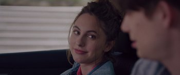 Movie still from “Alex Strangelove” (2018), directed by Craig Johnson – A young woman sitting in a car looking at the camera; Close Up shot, Over the shoulder angle