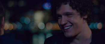 Movie still from “Alex Strangelove” (2018), directed by Craig Johnson – A person smiling at night; Close Up shot, Over the shoulder angle