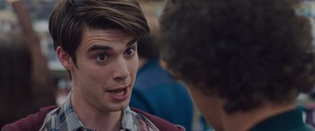 Movie still from “Alex Strangelove” (2018), directed by Craig Johnson – A young man with a surprised look on his face talking to another man; Close Up shot, Over the shoulder angle