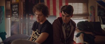 Movie still from “Alex Strangelove” (2018), directed by Craig Johnson – Two young men sitting next to each other in front of a laptop computer; Medium shot, Over the shoulder angle