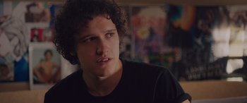 Movie still from “Alex Strangelove” (2018), directed by Craig Johnson – A man with curly black hair is looking at the camera; Close Up shot, Over the shoulder angle