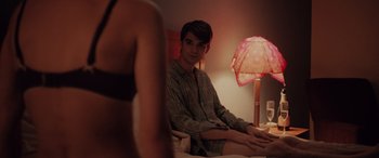 Movie still from “Alex Strangelove” (2018), directed by Craig Johnson – A man sitting on a bed next to a woman; Medium shot, Over the shoulder angle