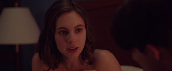 Movie still from “Alex Strangelove” (2018), directed by Craig Johnson – A woman sitting on a bed looking at the camera; Close Up shot, Over the shoulder angle