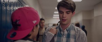 Movie still from “Alex Strangelove” (2018), directed by Craig Johnson – A young man holding onto a backpack while talking to another man; Close Up shot, Over the shoulder angle