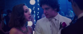 Movie still from “Alex Strangelove” (2018), directed by Craig Johnson – A man and a woman in formal wear at a party; Close Up shot, Over the shoulder angle