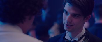 Movie still from “Alex Strangelove” (2018), directed by Craig Johnson – A man in a suit and tie talking to another man; Close Up shot, Over the shoulder angle