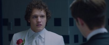 Movie still from “Alex Strangelove” (2018), directed by Craig Johnson – A man in a white suit looking into a mirror; Close Up shot, Over the shoulder angle