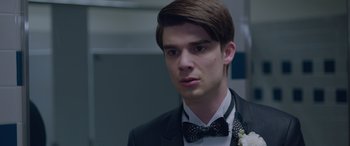 Movie still from “Alex Strangelove” (2018), directed by Craig Johnson – A man in a suit with a bow tie; Close Up shot, Over the shoulder angle