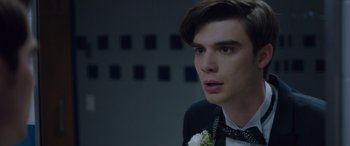 Movie still from “Alex Strangelove” (2018), directed by Craig Johnson – A young man in a suit and a bow tie; Close Up shot, Over the shoulder angle