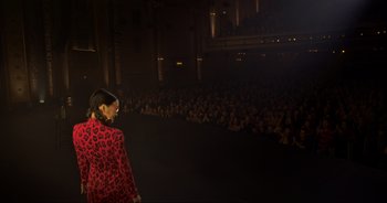 Movie still from “Ali Wong: Don Wong” (2022), directed by Nahnatchka Khan – A woman walking down a runway in front of a crowd; Extreme Wide shot, High angle